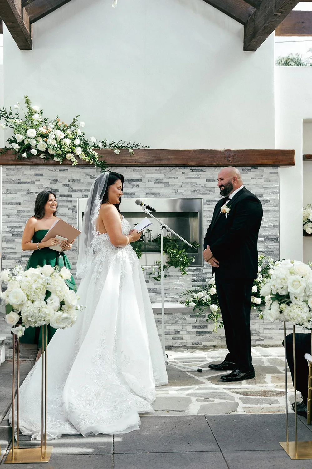 Parisa smiling as she officiates a wedding ceremony in an emerald dress